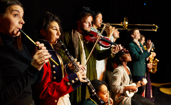 Actors and musicians playing instruments on stage