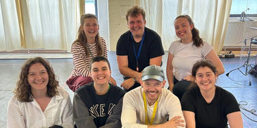 Seven creatives from Leeds Conservatoire sitting in rehearsal space in two rows